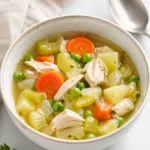Chicken and vegetable freezer soup with chicken, carrots, celery, potatoes, peas, and broth.