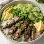 Crispy sardine rice bowl with lemon cucumber, herbs, green onion, and avocado.