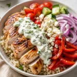 Easy Mediterranean chicken bowl with rice, cucumber, tomatoes, feta, and tzatziki.