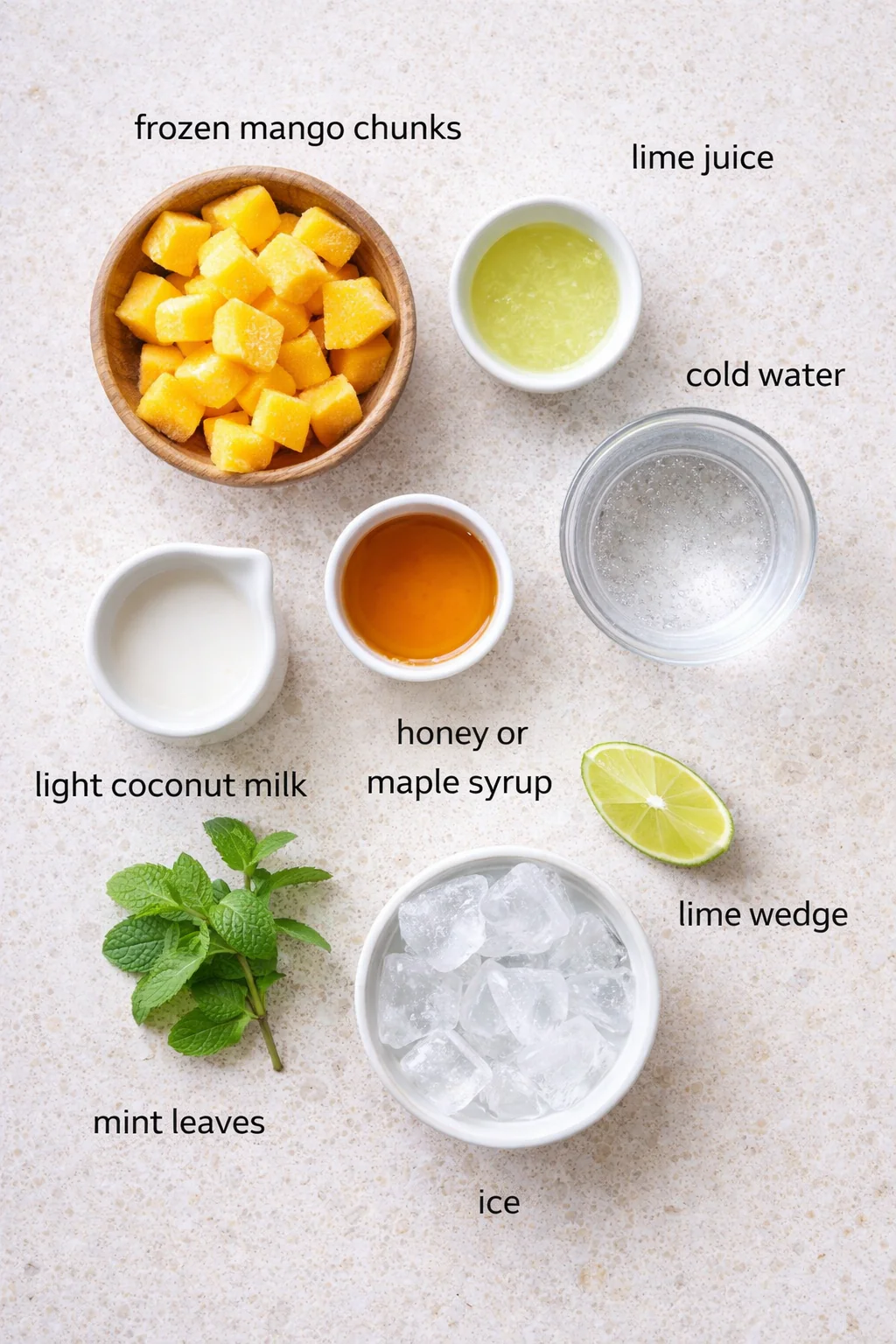 Bowl of frozen mango chunks and citrus on a table